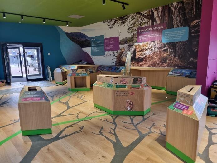 Interior of Scotland's Wildlife Discovery Centre showing trees printed on the floor, interpretation and engagement pods, and images on the wall. 