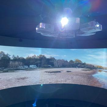 Interior of the Spirit of the Highlands &amp;amp; Islands immersive 360 degree portal, with two visitors admiring the film of the ferry sailing to the Isle of Arran